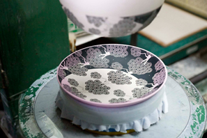 際まで描かれた細かなデザインが、皿のカーブで歪まないよう、パット印刷という技法を用いて制作