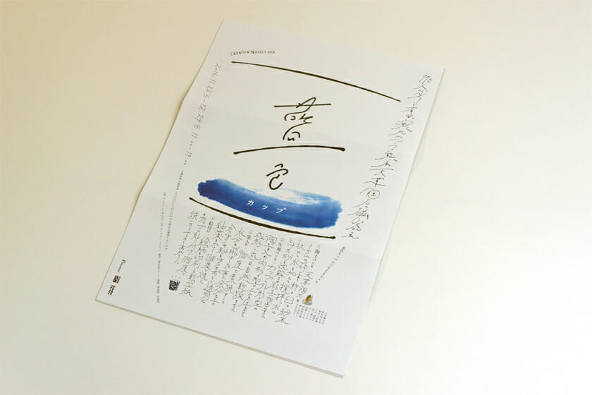 藍色カップ(展覧会フライヤー)。170人のクリエイターと有田の窯元がつくる磁器展のフライヤー。デザインは大原大二郎さんが担当。既成の文字はほとんど使わず、手描きの文字と線で構成された仕上がりはインパクト大!