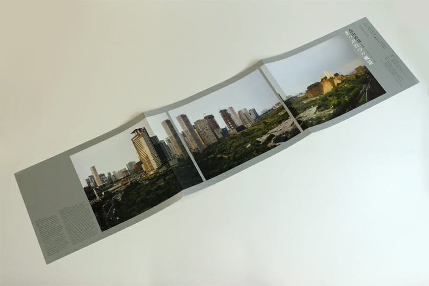 畠山直哉 写真展 まっぷたつの風景(展覧会フライヤー)。横長に三面開きになるフライヤーは、長細い窓から風景を見ているかのよう。光沢のある銀色の紙に印刷された、贅沢な仕上がりです