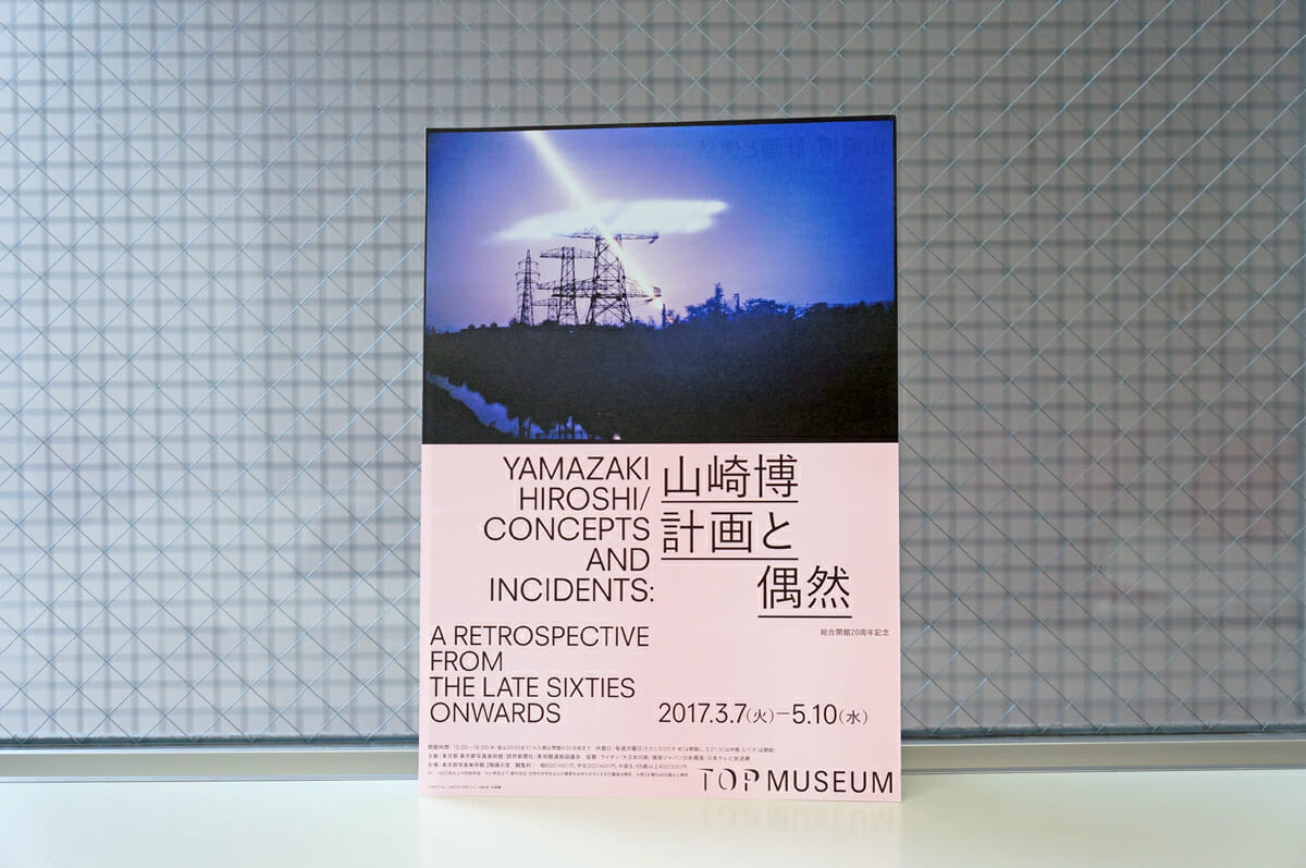 山崎博　計画と偶然（展覧会フライヤー）。東京都写真美術館で開催された、作家の山崎博さんの仕事をたどる展覧会。ベタ面の薄ピンクと、写真のパキッと分かれた構成が潔い一点。絶妙に組まれている、文字のバランスにも注目です