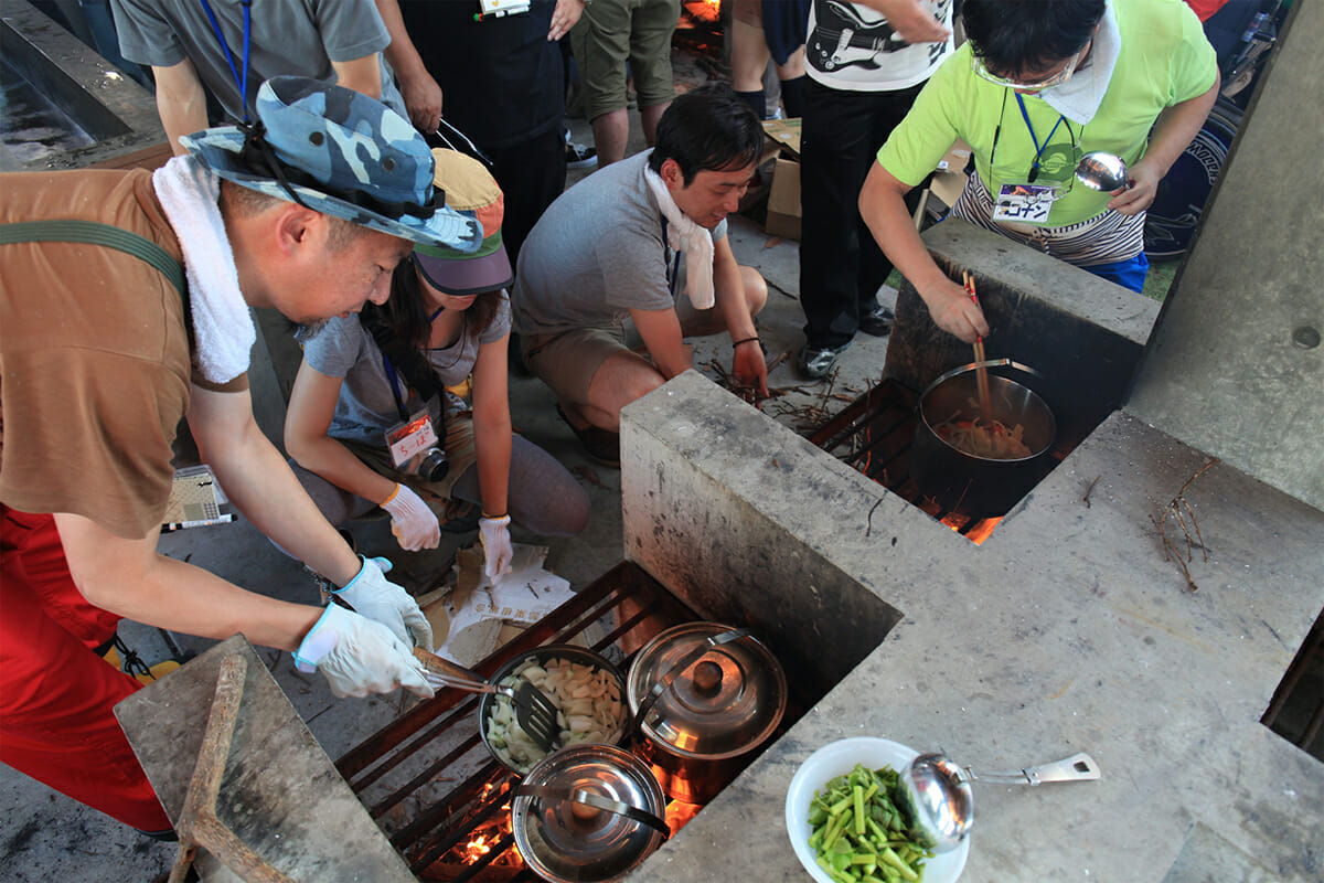 多様なメンバーが協力して料理をつくる（ユニバーサルキャンプ in ⼋丈島）