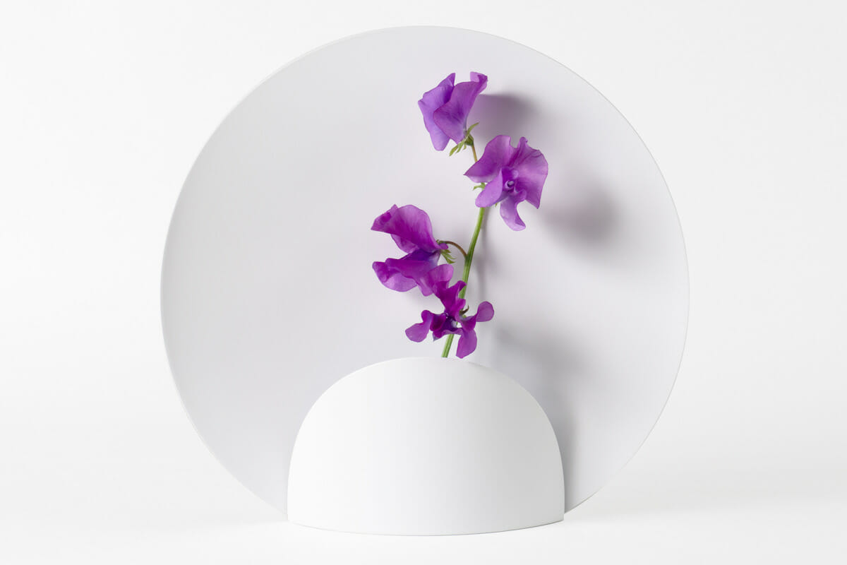 東京の調布市で事務所兼店舗を運営するデザイン事務所「OGUCHI DESIGN」の花瓶「Picture」。花の一瞬一瞬を描き出す花瓶として、活けた花を美しく際立たせるための円形の背景が取り付けられている。https://www.shinyaoguchi.com