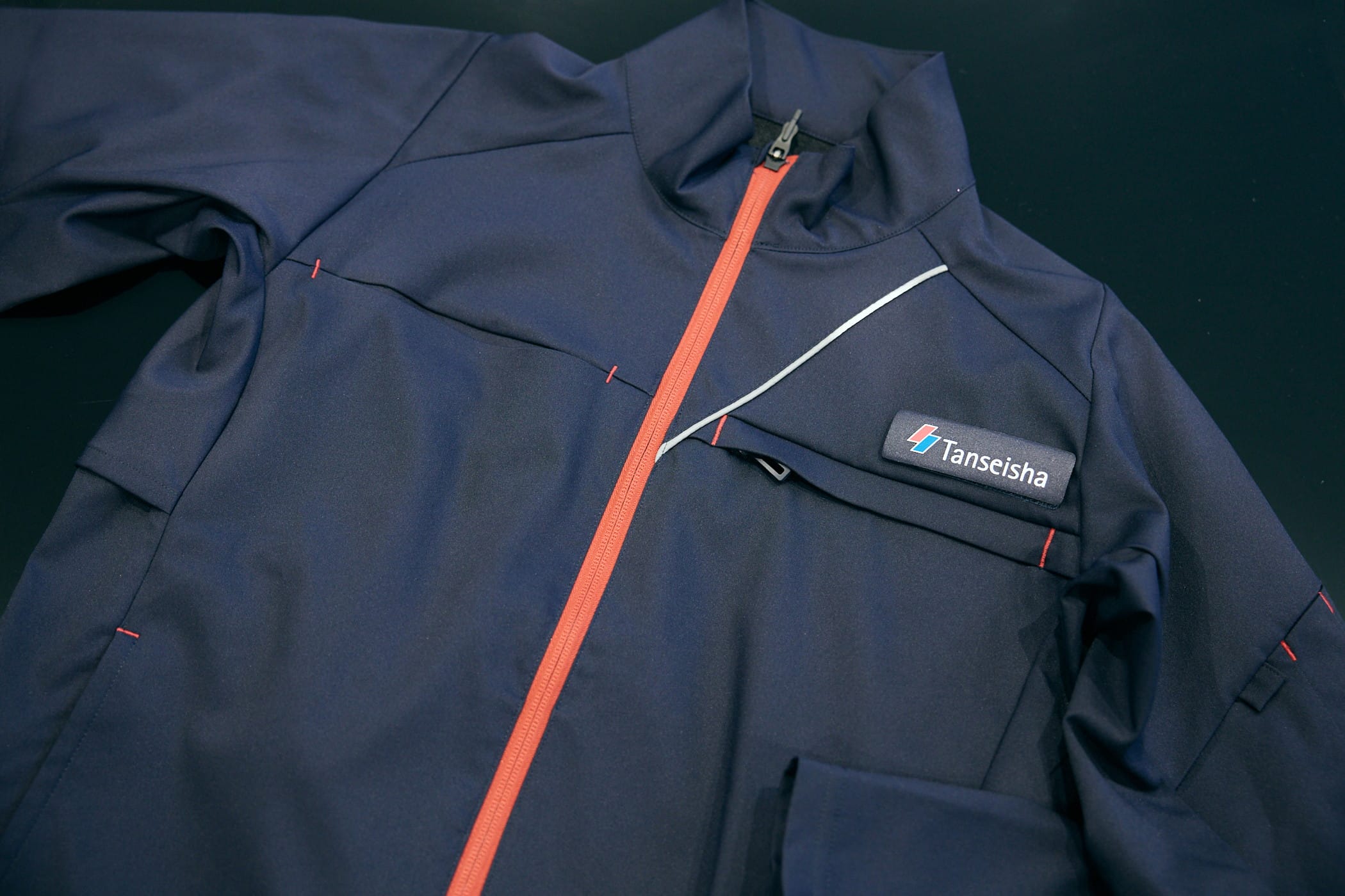 コーポレートカラーを反映した赤い糸が施されたポケット