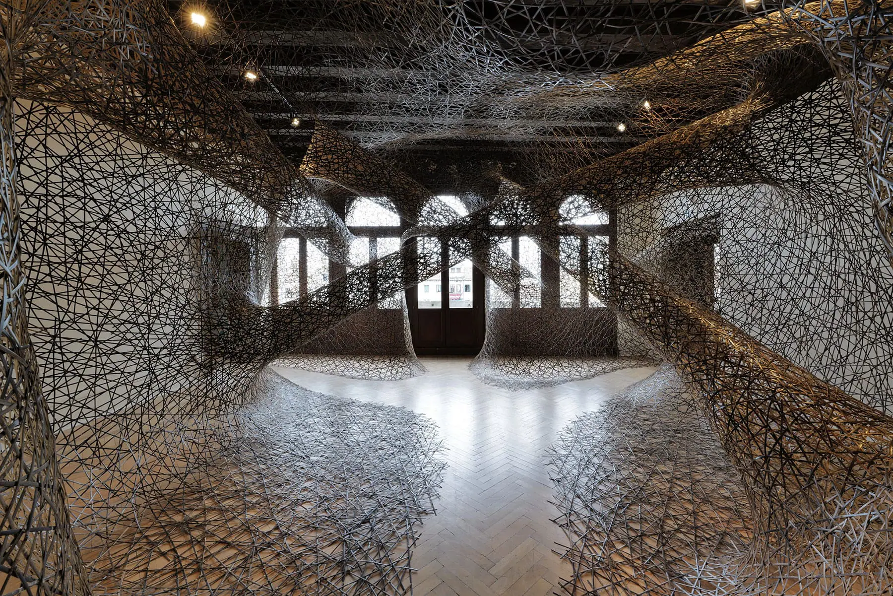 展示室の空間を覆いつくすように設置された、竹工芸作品の展示風景
